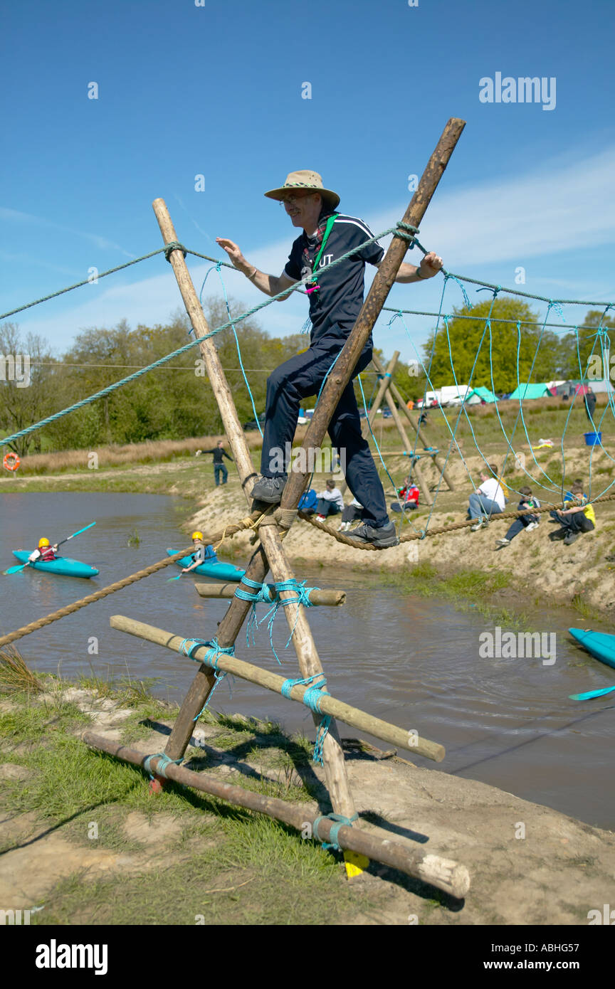 Scouts et traverser un pont de corde leader sur une rivière Banque D'Images