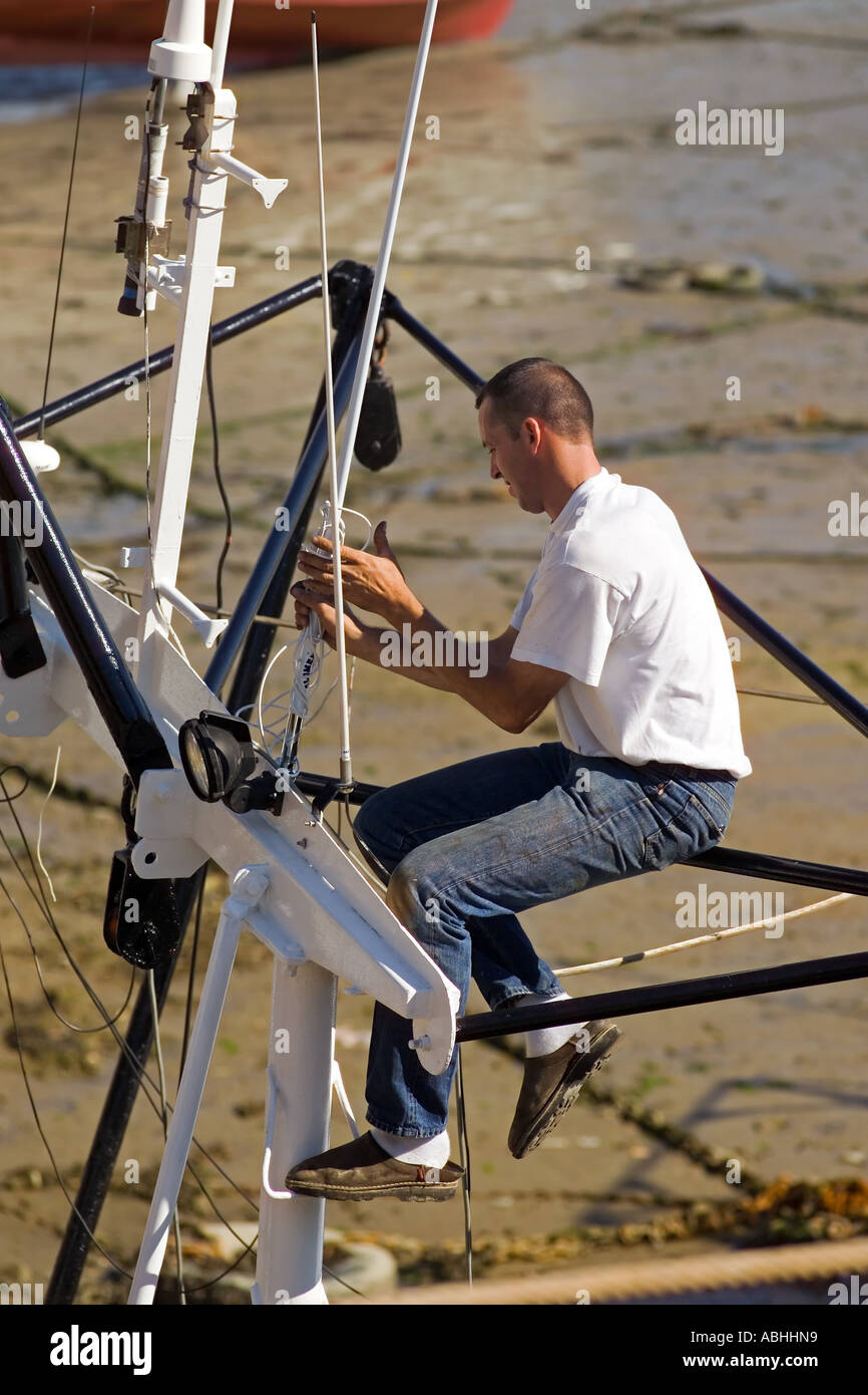 Fixation de l'ANTENNE RADIO PÊCHEUR SUR BATEAU DE PÊCHE CHALUTIER À MARÉE  BASSE PORT ERQUY BRETAGNE FRANCE Photo Stock - Alamy