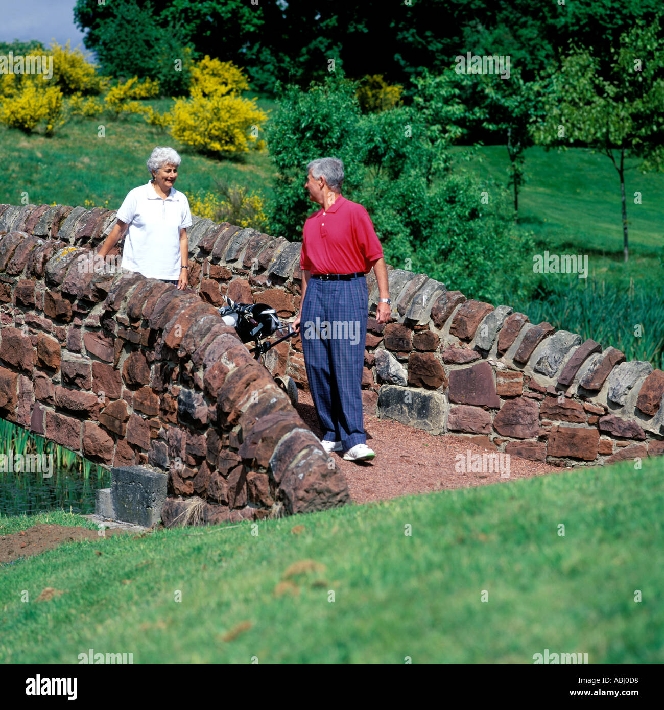 COUPLE EN TRAIN DE MARCHER AU COURS DE GOLF. Parution du modèle. Banque D'Images