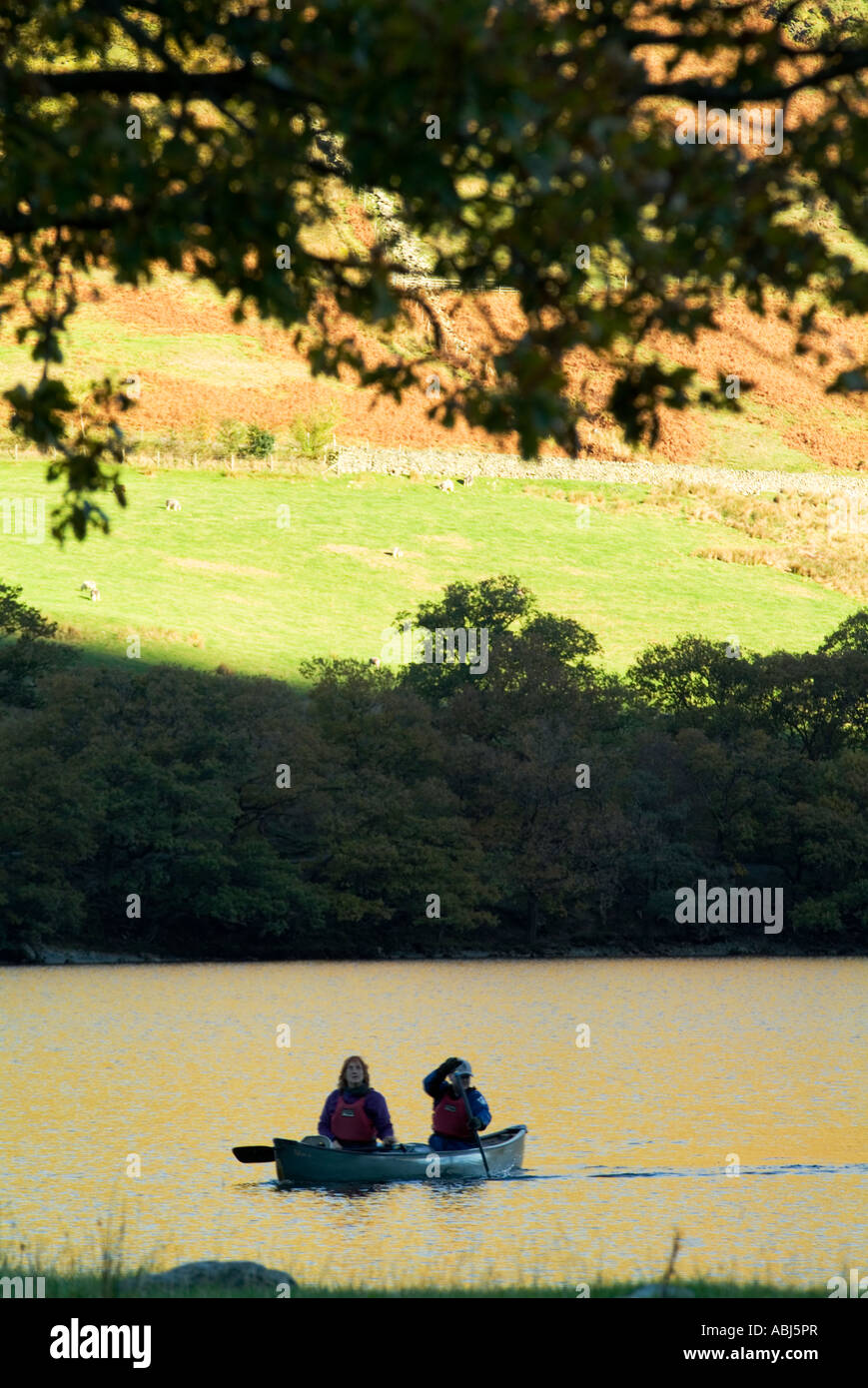 Canoës flottent doucement sur le lac de la lande au coucher du soleil sur une glorieuse atumn journée dans le district d'english lake montagnes ensoleillées Banque D'Images