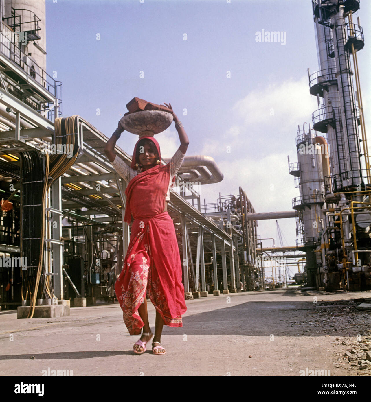 Une chose commune dans l'Inde est une femme Harijan transportant une charge de briques sa tête. Vu à une usine pétro-chimique nr Mumbai (Bombay) Banque D'Images