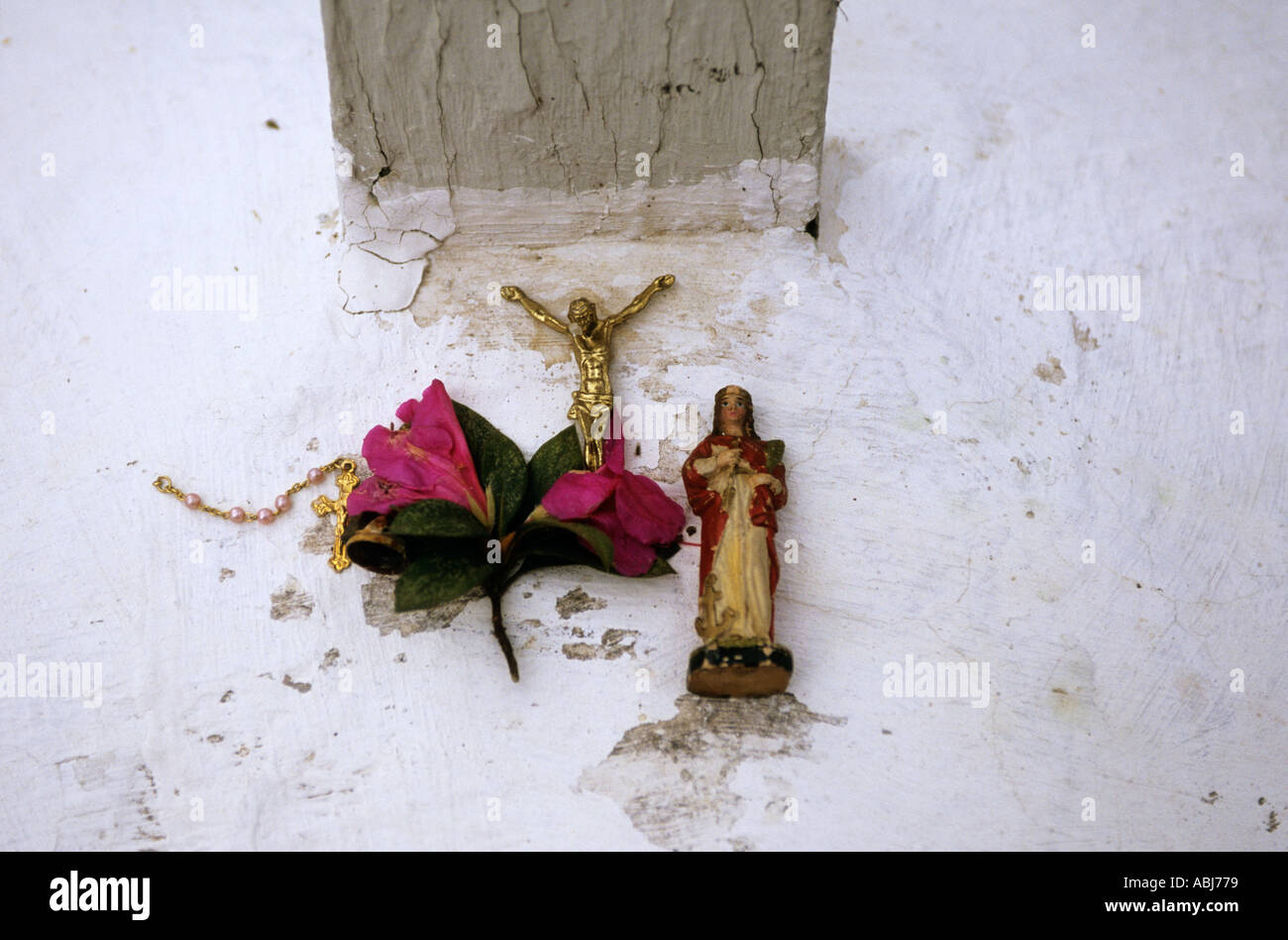 Sao Paulo, Brésil. Affichage religieux typique sur un mur blanc (croix, Jésus, fleurs). Banque D'Images