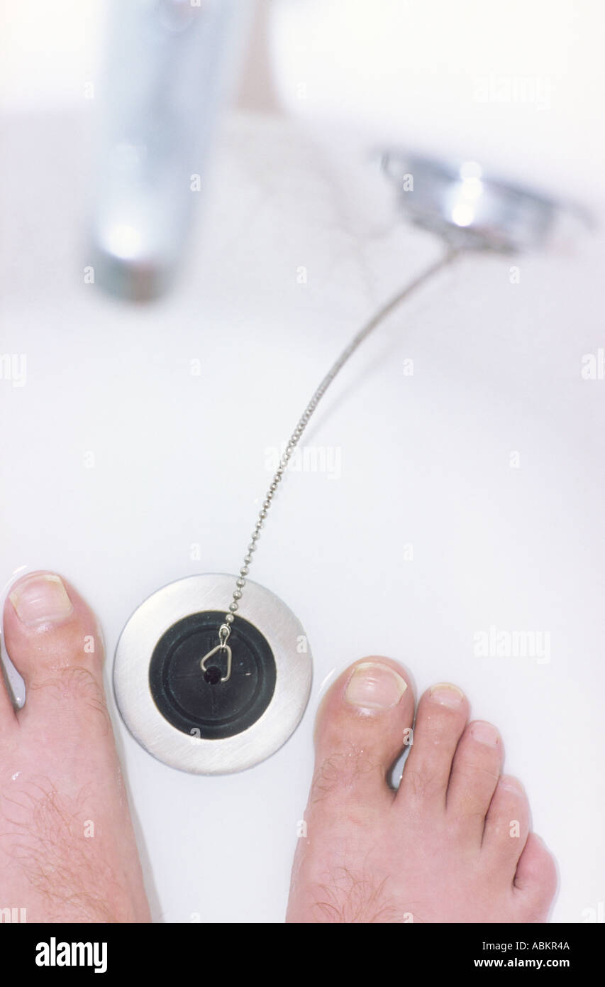 Thème de l'environnement en regardant les pieds tout en se trouvait dans une baignoire vide pratiquement vide en raison d'une grave pénurie d'eau Banque D'Images