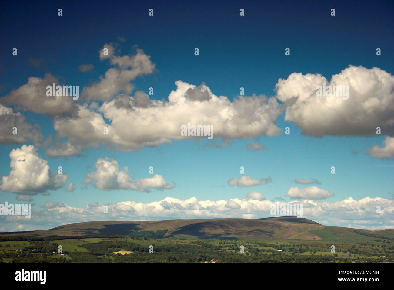 Photo de paysage horizontal de Pendle Hill East Lancashire sur une journée ensoleillée avec ciel bleu et nuages blancs moelleux Banque D'Images