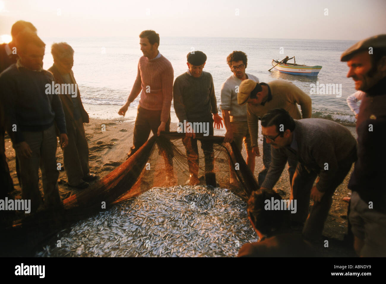 Les pêcheurs espagnols sur la côte de sable de la Méditerranée à Costa del Sol avec filet poisson dans la lumière du matin Banque D'Images