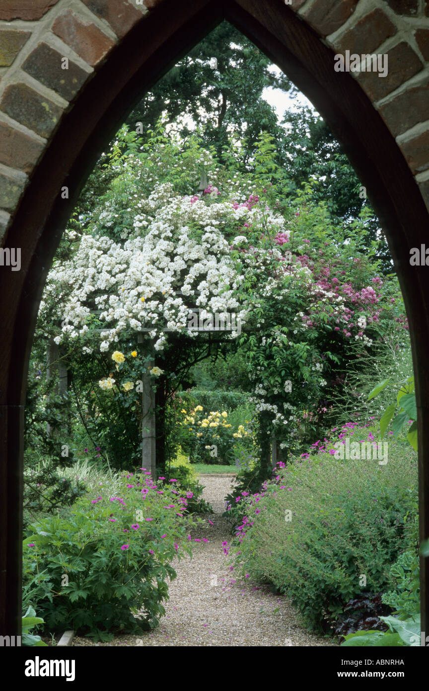 Vue à travers l'arche à la Roseraie, pergola, Mannington Hall, Rosa 'Rambling Rector', Norfolk, Angleterre, Royaume-Uni Banque D'Images