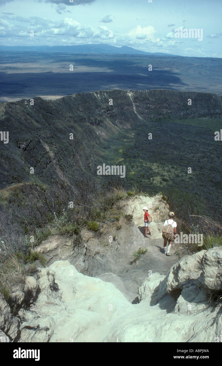 Deux jeunes marcheurs en ordre décroissant le bord du cratère du sommet du mont Longonot Kenya Afrique de l'Est Banque D'Images