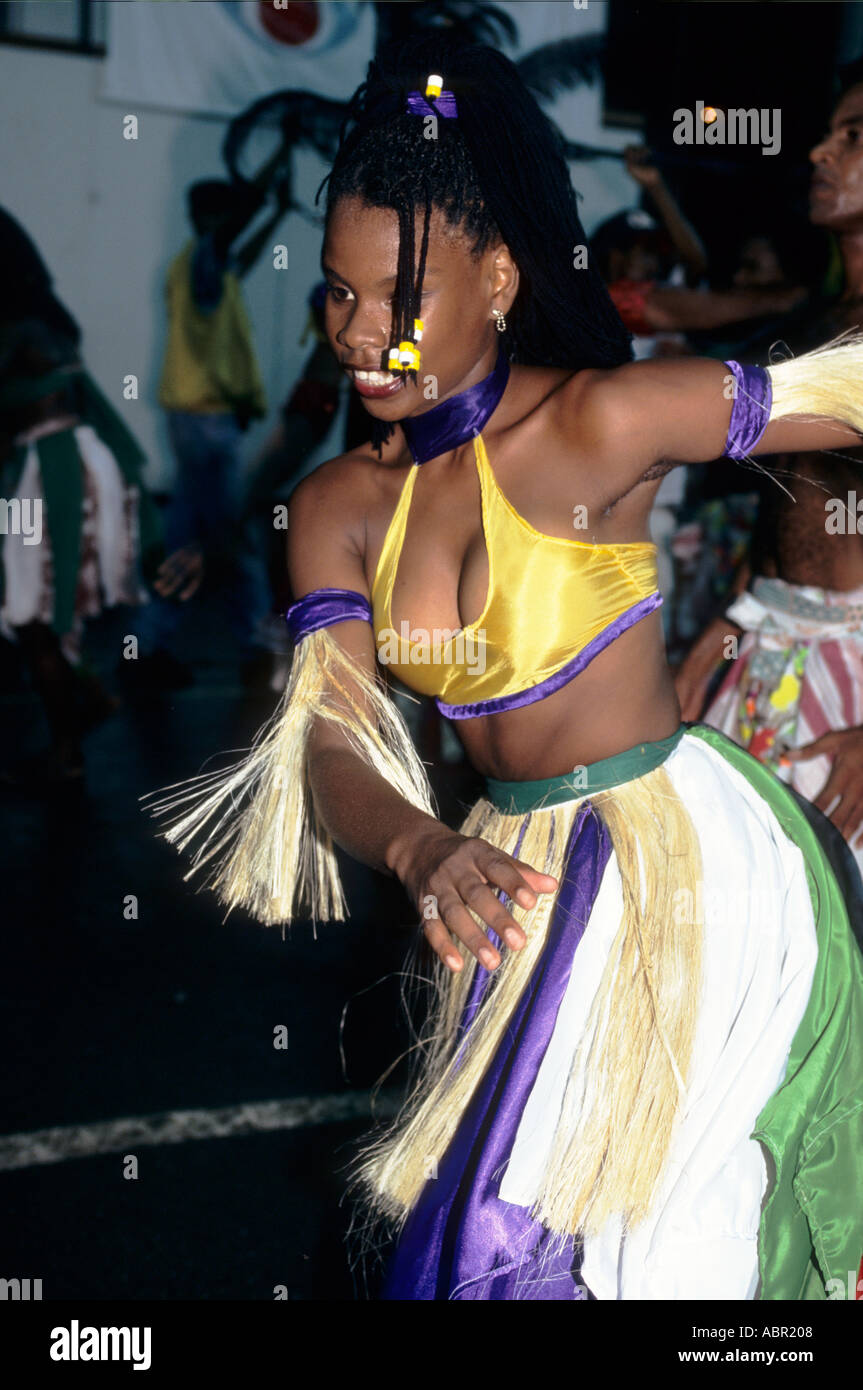 Salvador, Etat de Bahia, Brésil. Fille en vert, violet, blanc et jaune avec de l'herbe de costume de danse au décorations de carnaval. Banque D'Images