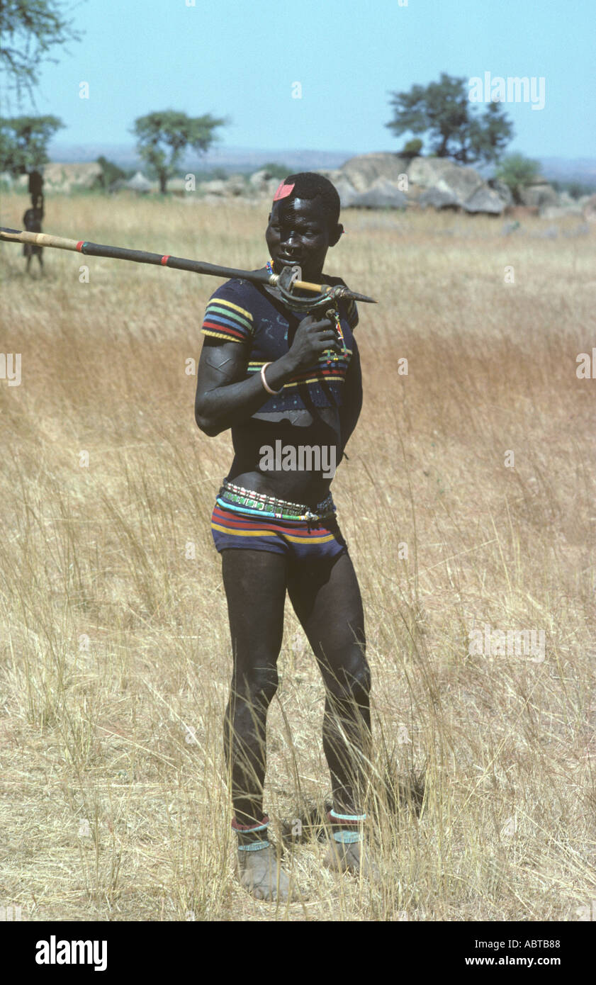 Stick Nuba wrestler guerrier dans la laine correspondante twinset malgré 100 degré d'humidité et de la température ambiante élevée au sud de Kadugli N Banque D'Images