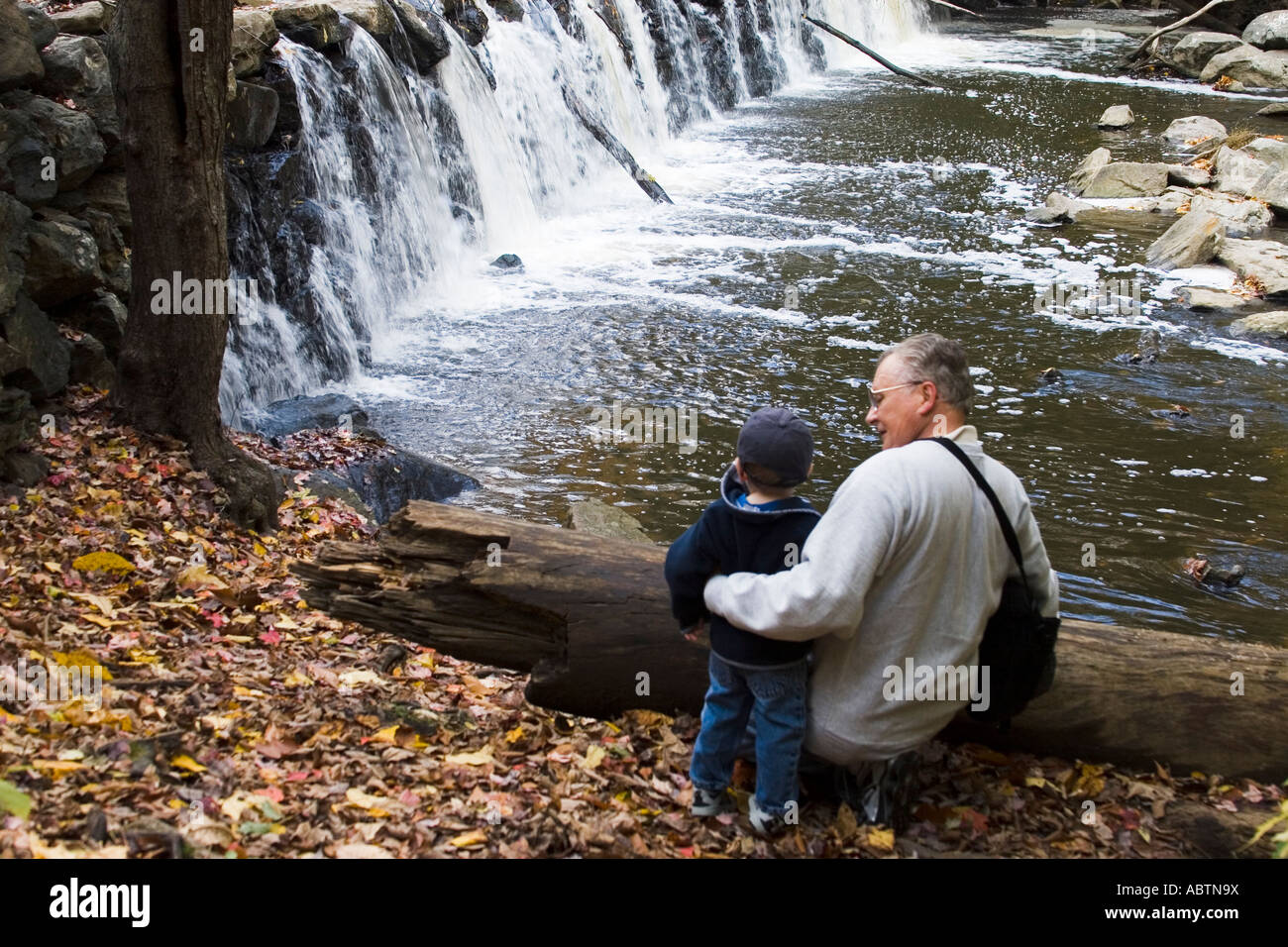 Grand-père avec son petit-fils est arrêté pour voir une cascade en marchant dans les bois de Ridley Creek State Park en Pennsylvanie Banque D'Images