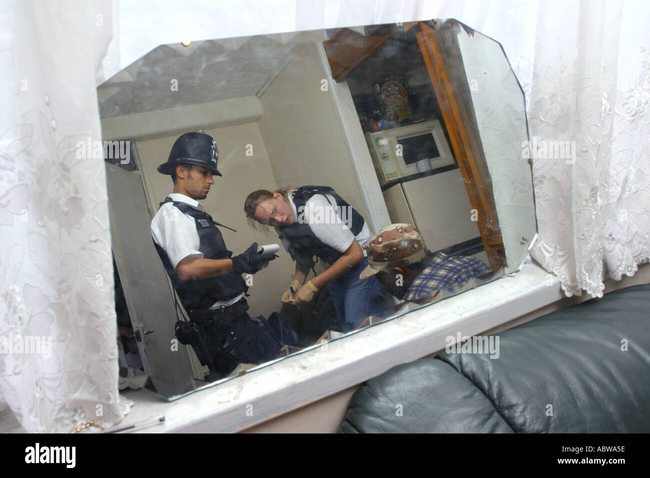 Question de police un suspect au cours d'un raid de la drogue d'un appartement à Leyton, East London, UK. Banque D'Images