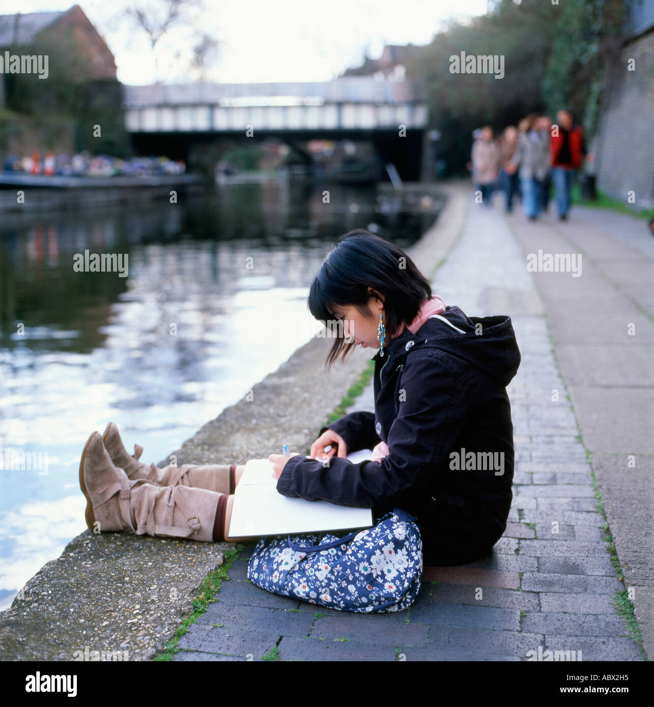 Chinese female student sitting art dessin sur le chemin de halage par le Regents Canal dans Camden Lock en automne Londres Angleterre Royaume-uni KATHY DEWITT Banque D'Images Chinese female student sitting art dessin sur le chemin de halage par le Regents Canal dans Camden Lock en automne Londres Angleterre Royaume-uni KATHY DEWITT Banque D'Images