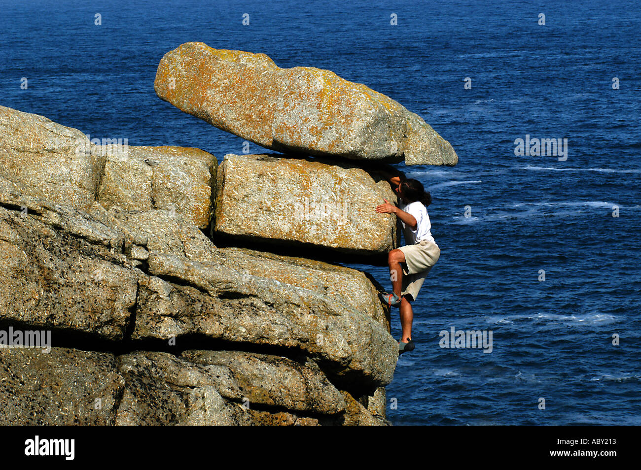 Jeune homme escalade près de Sennen Cove, Cornwall, Angleterre Banque D'Images