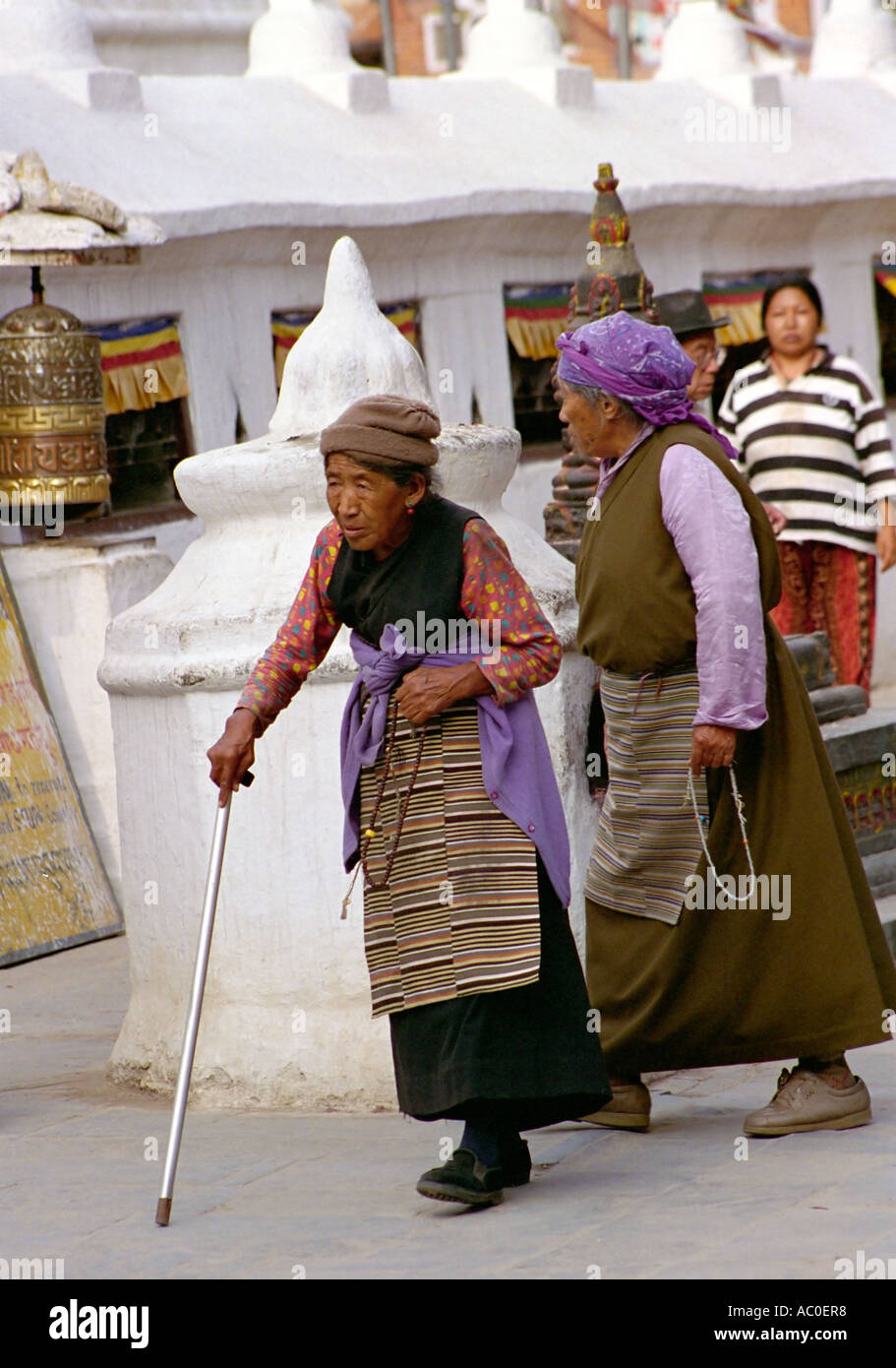 Vieille Femme tibétaine avec stick marche autour du stupa de Bouddhanath près de Katmandou Népal Asie du Sud Banque D'Images