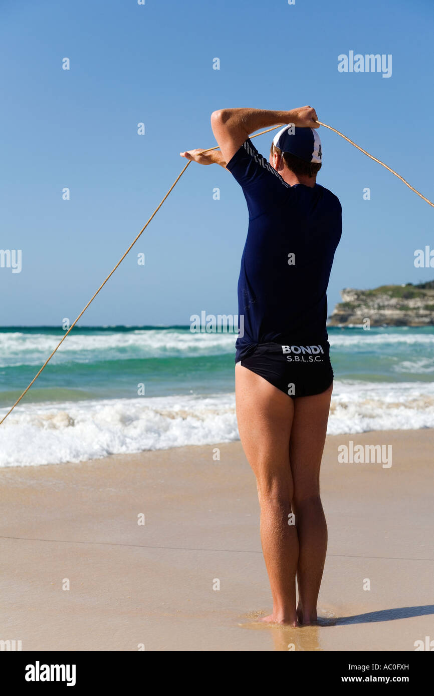 Une plage de Bondi lifesaver laisse échapper à la corde pour une plage traditionnelle à l'aide d'une ceinture de sauvetage et de ligne Banque D'Images