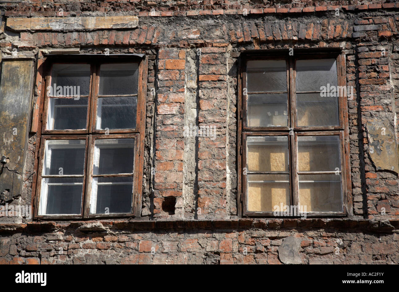 Double vitrage en bois ancienne couche dans le vieux bâtiment en briques rouges avec façade en plâtre enlevé pour rénovation kazimierz krakow Banque D'Images