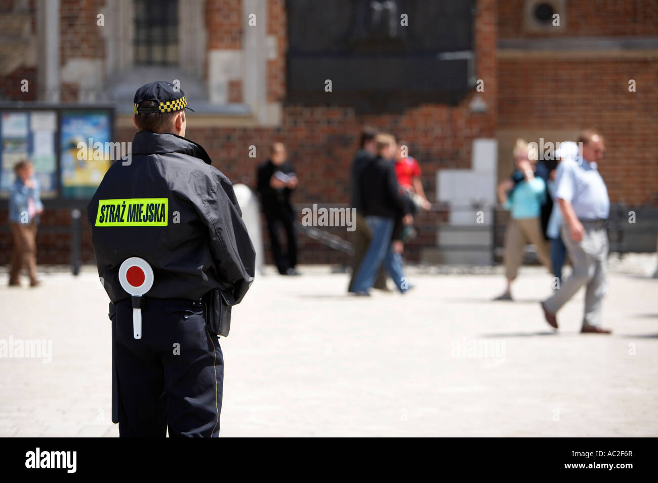 Dans l'agent de police municipal polonais debout regardant en patrouille dans la place Rynek Glowny krakow Banque D'Images