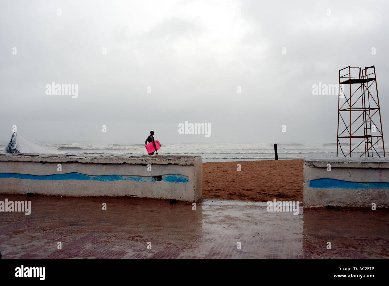 Lone surfer sur la plage en cas de mauvais temps à El Jadida Maroc Banque D'Images