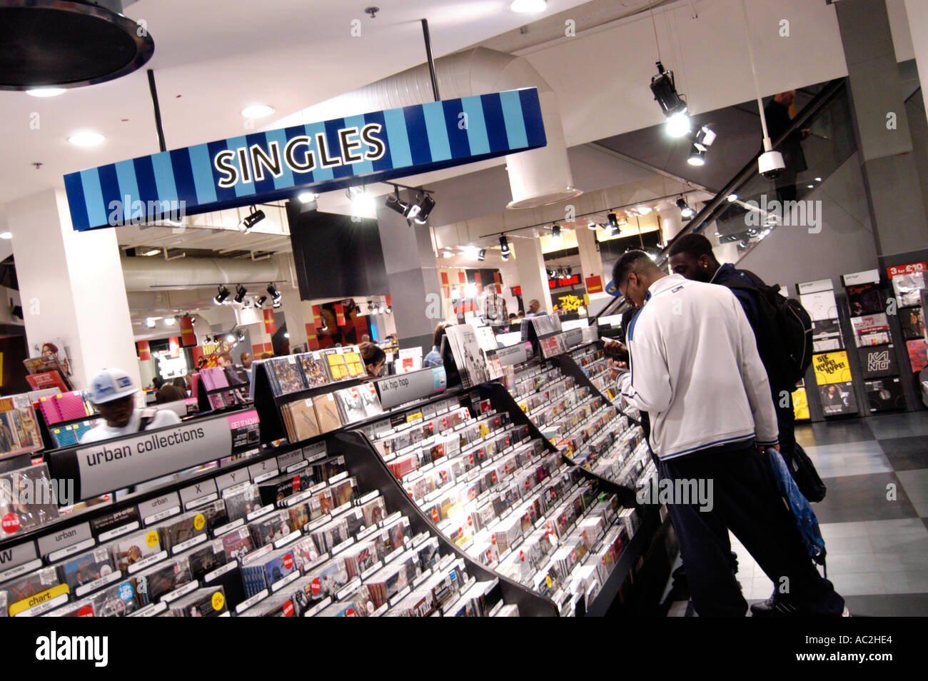 Les jeunes consommateurs en parcourant des célibataires CDs à HMV store London England UK Banque D'Images