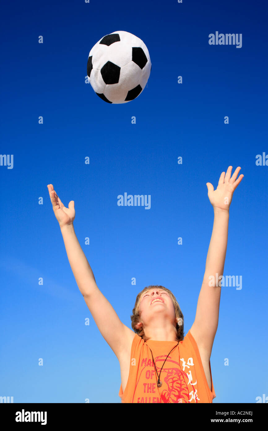 Portrait d'un jeune garçon jauntily lancer un ballon en l'air Photo Stock -  Alamy