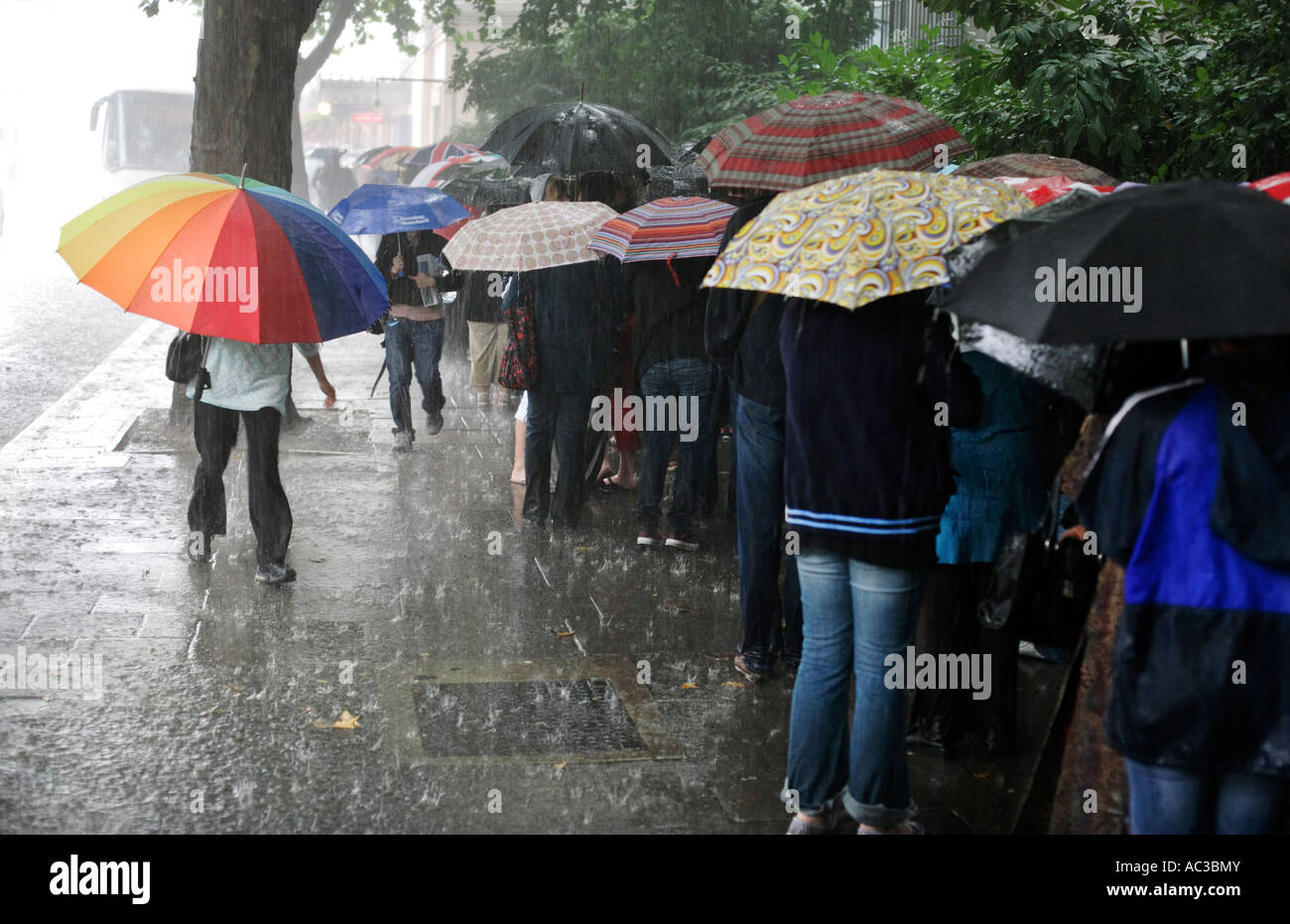 Les gens d'attente dans une tempête de pluie d'été pour Madame Tussaud sur Marylebone Road à Londres Banque D'Images