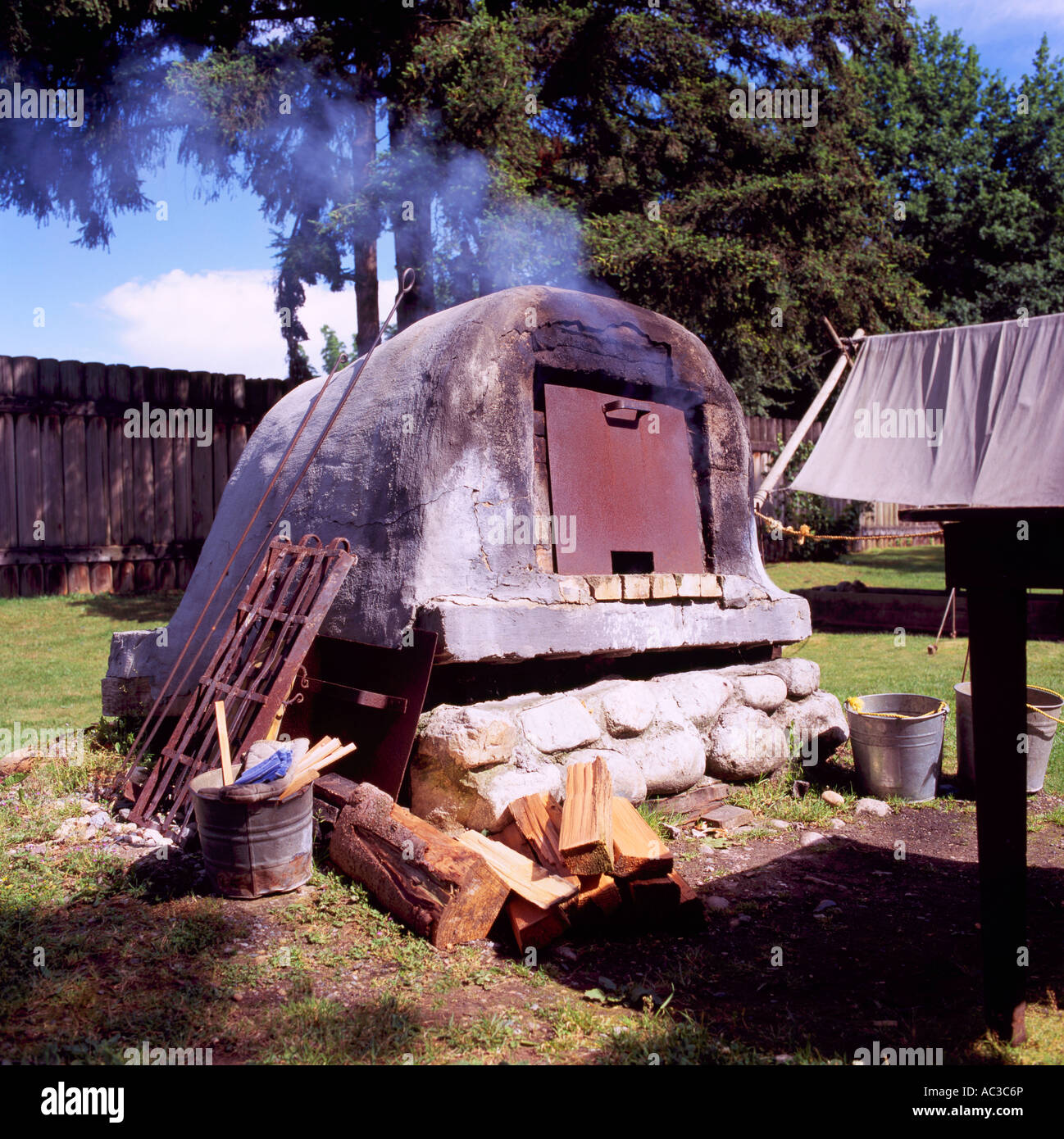 La cuisson du pain dans le vieux four en plein air au lieu historique national du Fort Langley, BC, British Columbia, Canada Banque D'Images