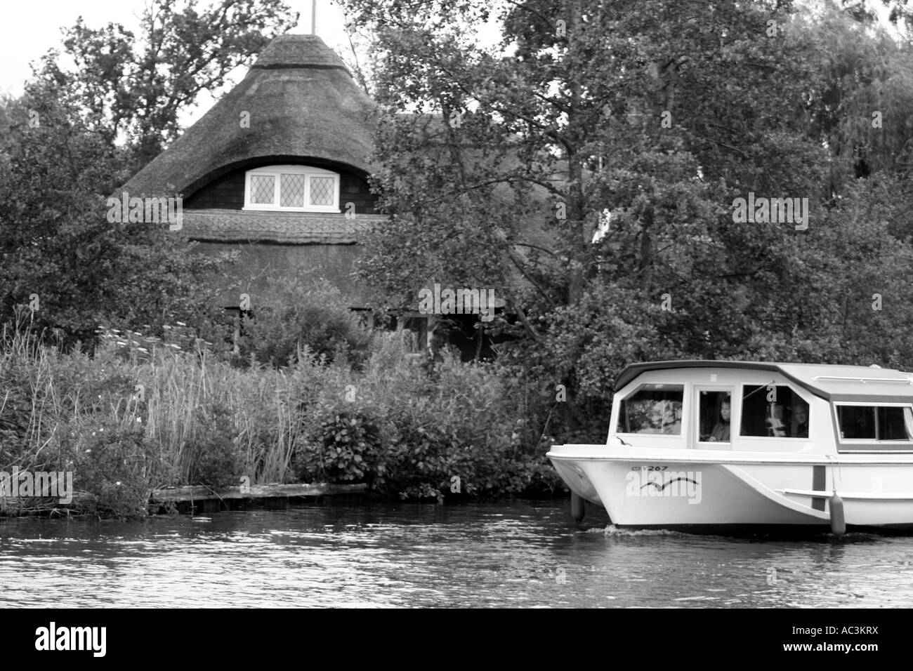 River Boat & maison au toit de chaume. Norfolk Broads Banque D'Images