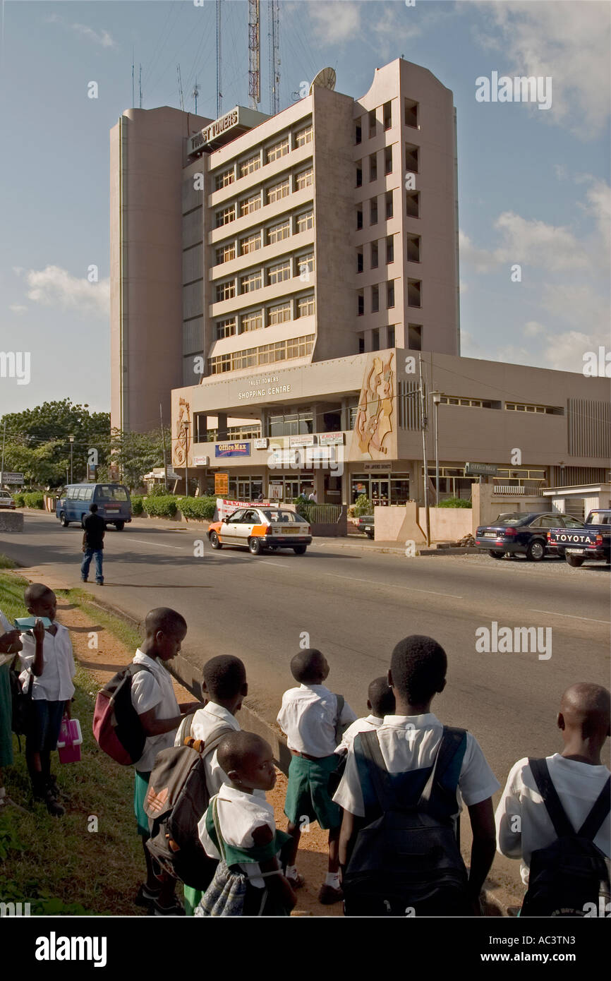 Les enfants de l'école attend de traverser la route en dehors de Trust Towers Shopping Center, Accra, Ghana Banque D'Images