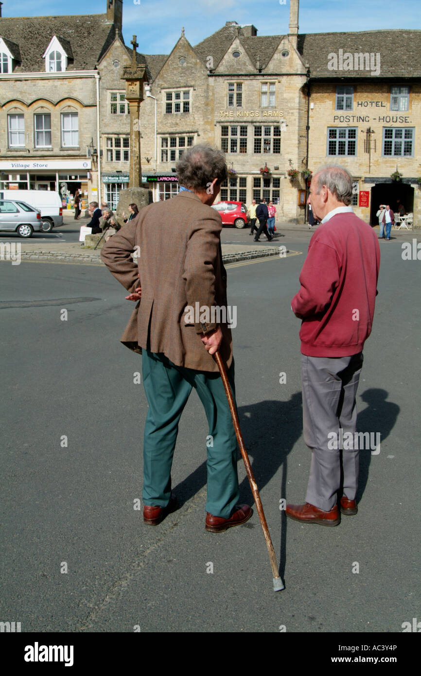 Hommes parler dans une rue. Stow on the Wold un marché Cotswold town dans le Gloucestershire England UK Banque D'Images