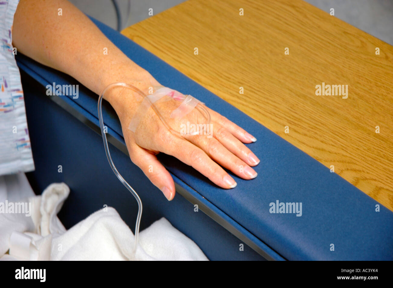Femme caucasienne d'âge moyen à l'hôpital en attente et en préparation pour l'opération sur les genoux endommagés blessés par le médecin avec de l'électronique et le mari Banque D'Images