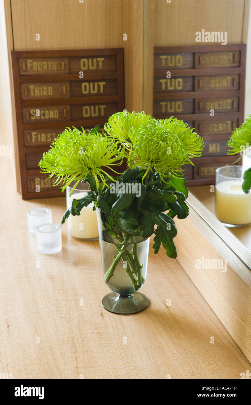 Vase de maman green spider chrysanthème sur surface en bois avec miroir et bougie Banque D'Images
