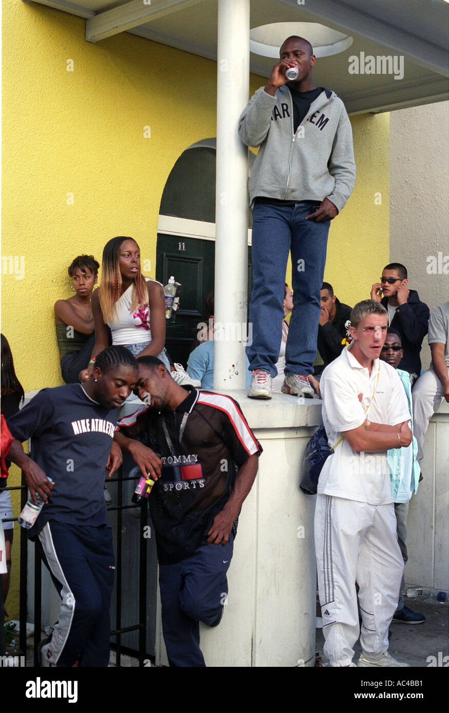 Groupe de jeunes de différentes races chat sur la porte à Londres pendant la festival de Notting Hill. Banque D'Images