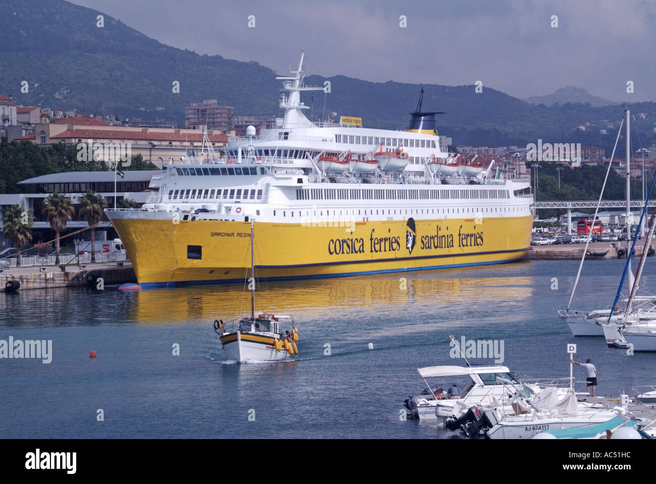 Port d'Ajaccio avec ferry amarré le long du front de mer dans un petit bateau de plaisance de passage Banque D'Images