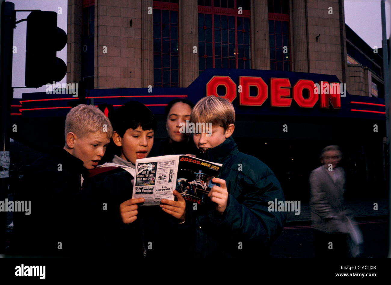 Les jeunes garçons à l'extérieur d'un cinéma Odeon Banque D'Images