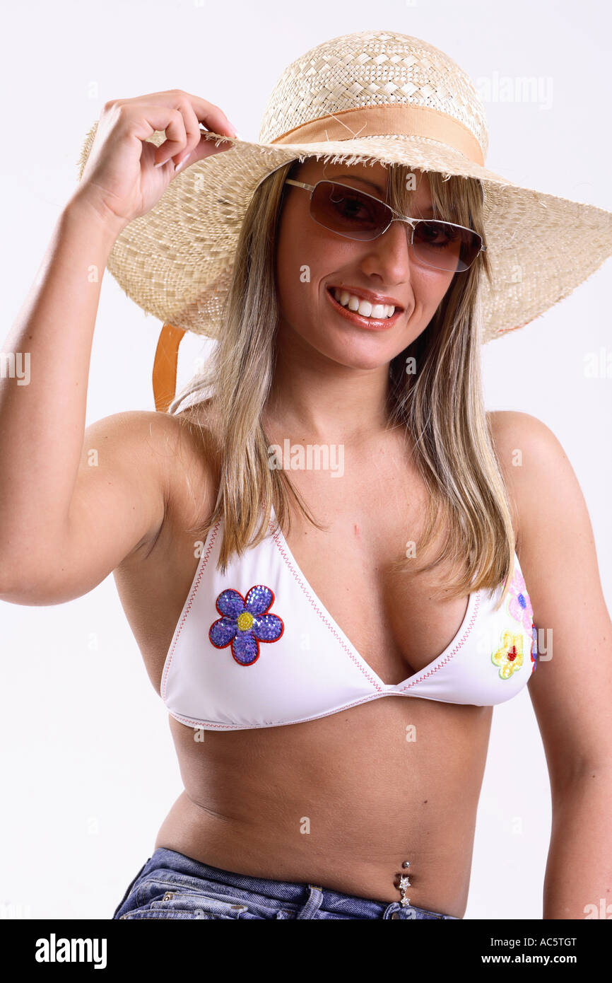 Junge Frau im Bikinioberteil und mit Sonnenbrille Strohhut jeune femme portant un bikini top un chapeau et des lunettes de soleil Banque D'Images