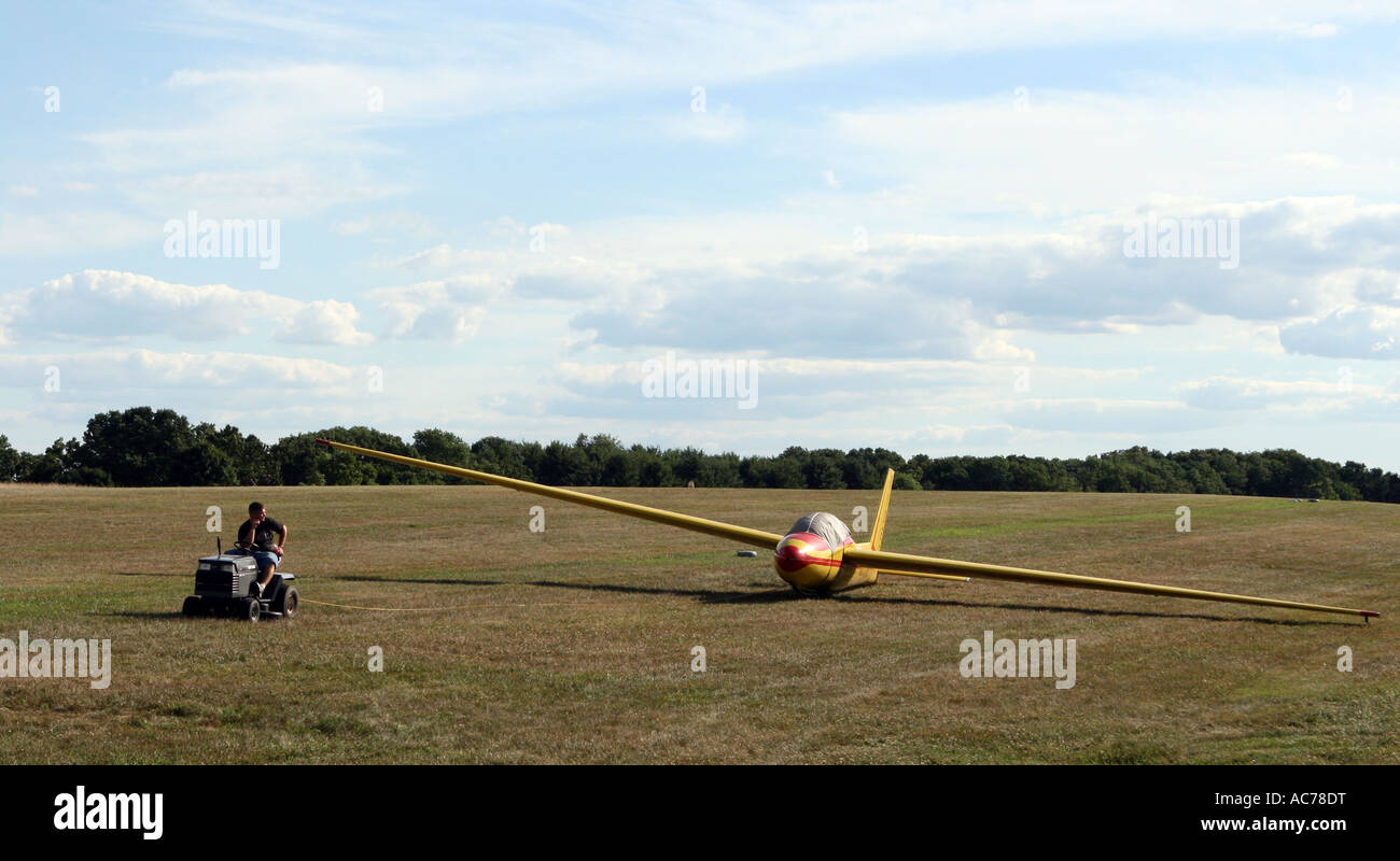 Un membre d'un équipage au sol de déménagement un planeur, parapente, avec un petit tracteur à jardin. Banque D'Images
