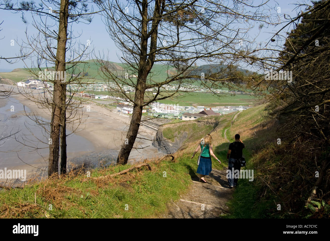 Deux jeunes gens qui marchent le long de la côte de Clarach Ceredigion bay holiday camp à Aberystwyth, Pays de Galles UK Banque D'Images
