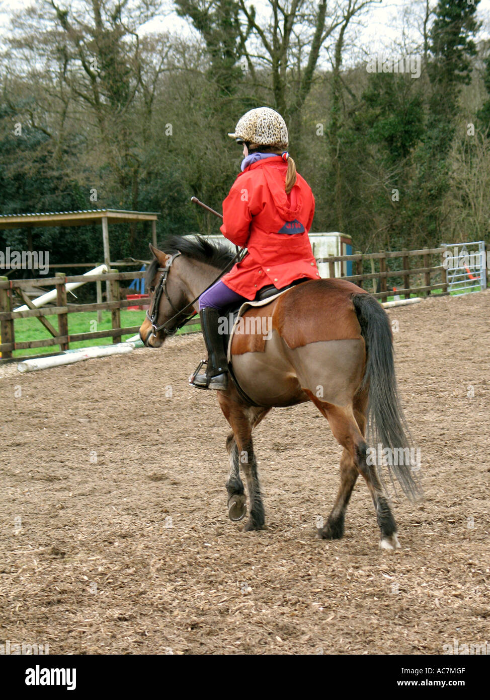 Jeune enfant équitation poney dans une école d'équitation Banque D'Images