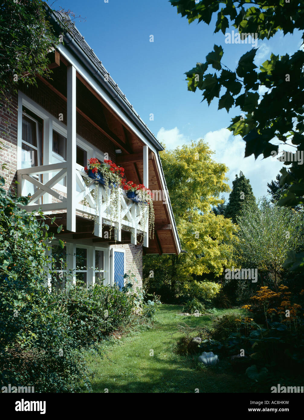 Petite maison de campagne traditionnel allemand avec des géraniums rouges sur balcon Banque D'Images