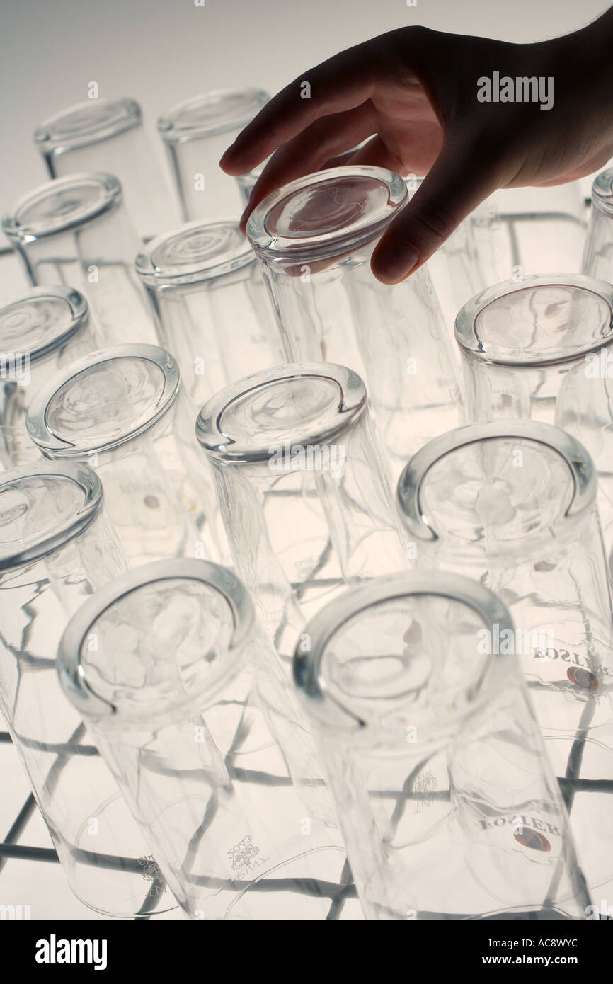 Personne dépose de verre vaisselle industrielle Banque D'Images