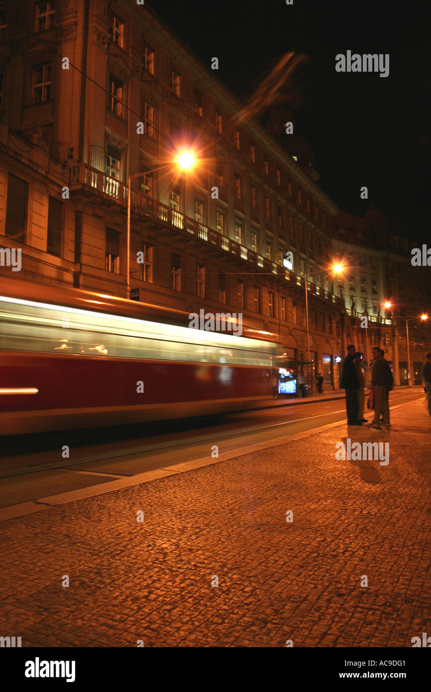 Une traînée de lumière : le tramway passe par une rue nocturne de Prague. Banque D'Images