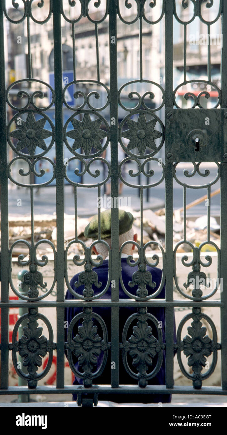 Vieil homme derrière la porte en fer ornemental à Lisbonne Portugal Banque D'Images