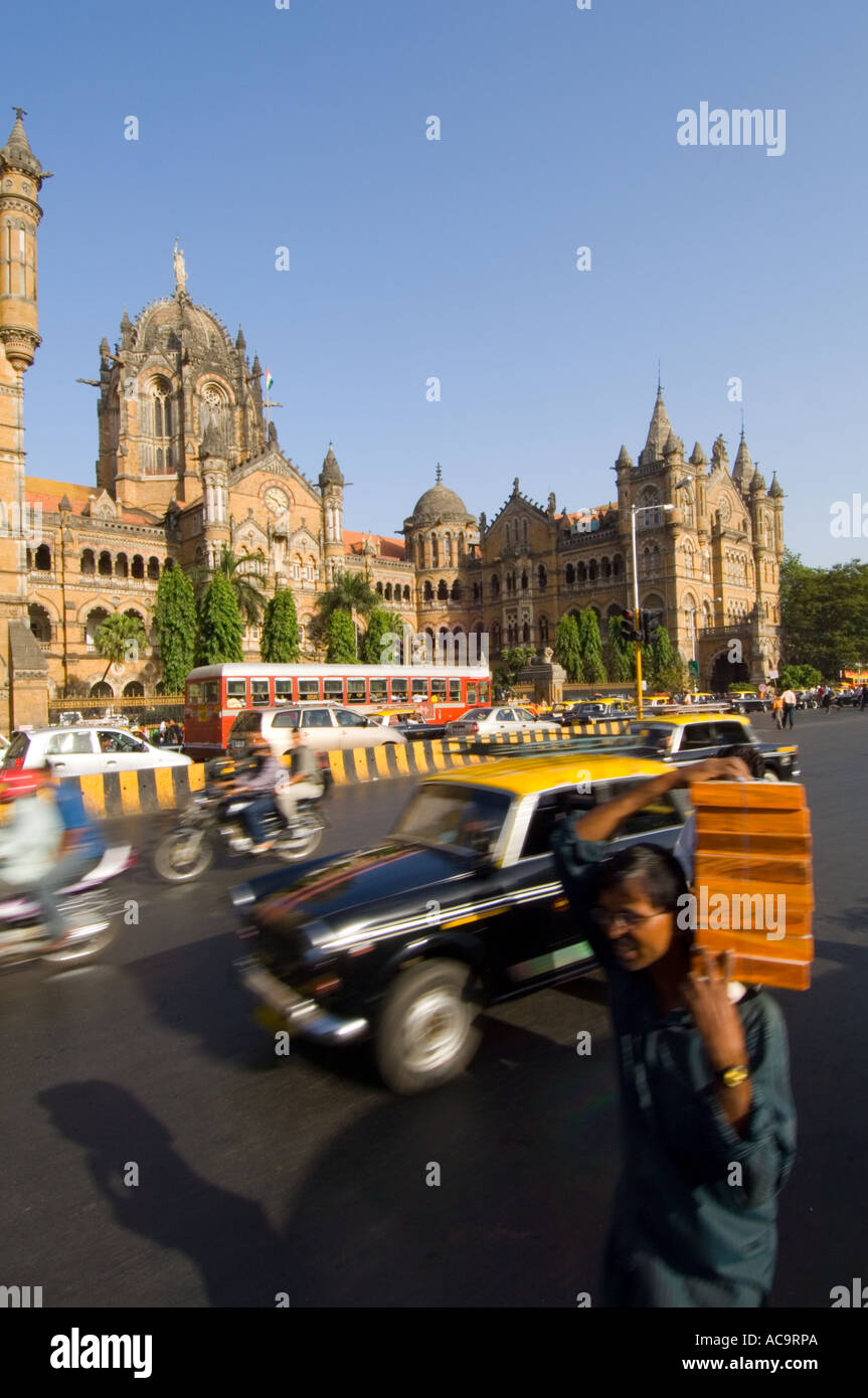 Le Victoria Terminus avec l'heure de pointe voyageant passé en particulier les taxis jaunes et noirs traditionnels de Mumbai. Banque D'Images