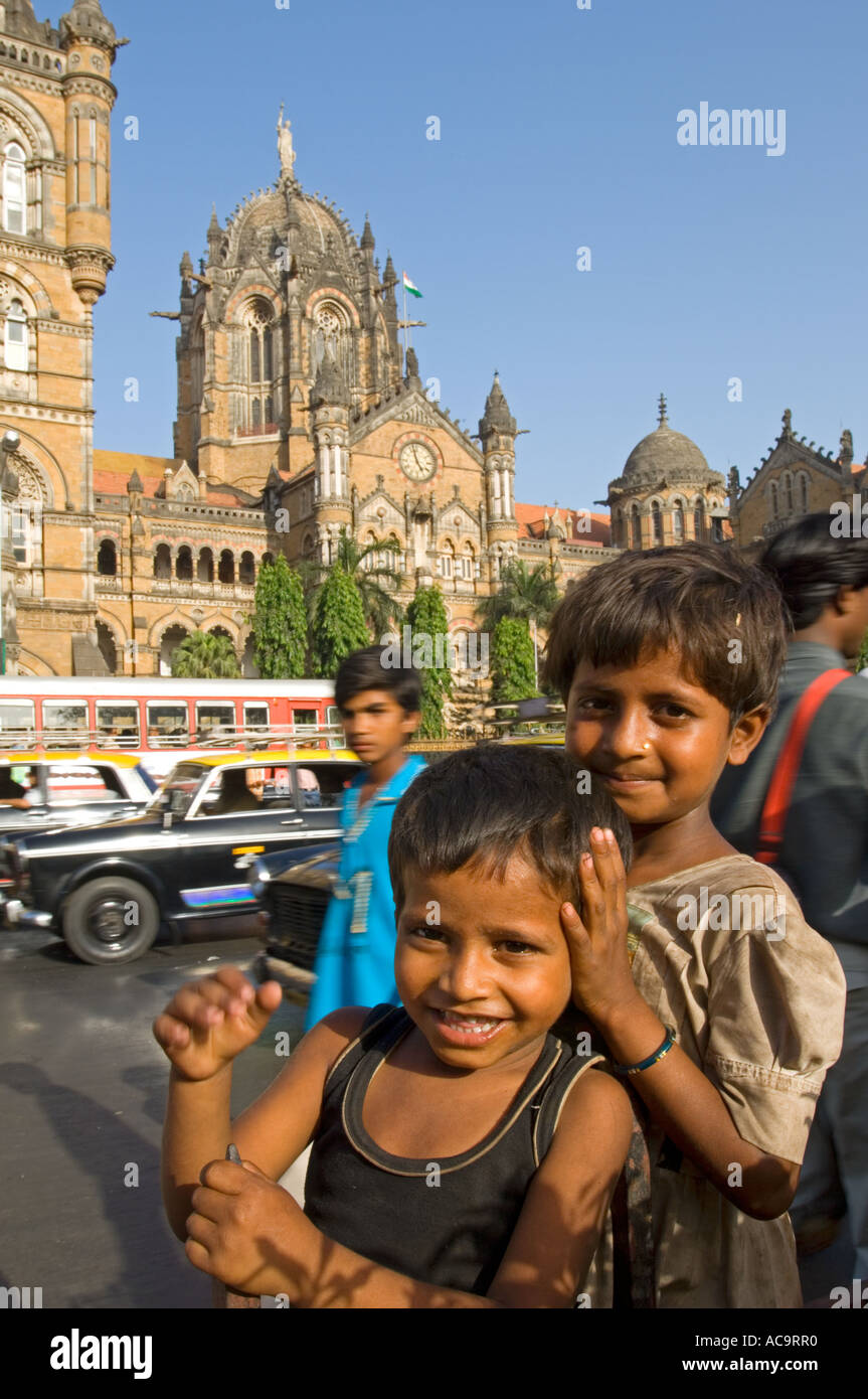 Les jeunes enfants des rues posent pour la caméra en face du Victoria Terminus avec l'heure de pointe un voyage passé. Banque D'Images