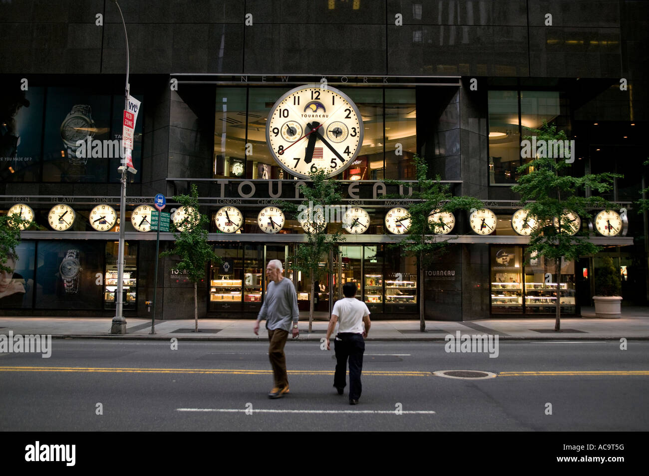 Les personnes qui traversent la rue devant un watch store sur la 57e rue à Manhattan Banque D'Images