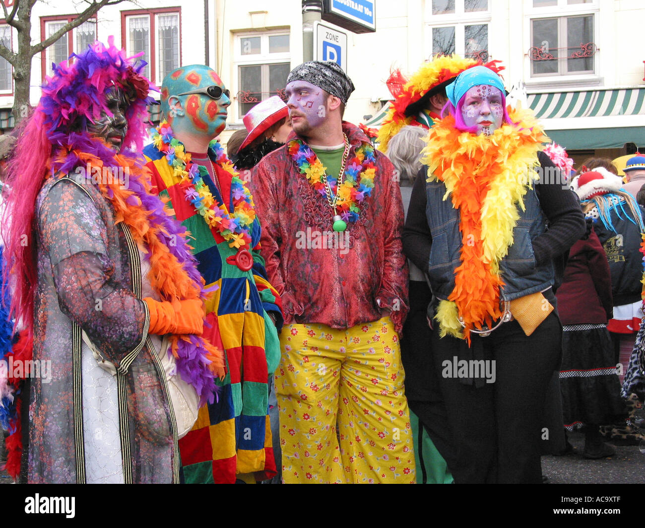 Quatre participants carnaval défilé regarder à partir de la route habillés en costumes colorés Pays-bas Maastricht Banque D'Images