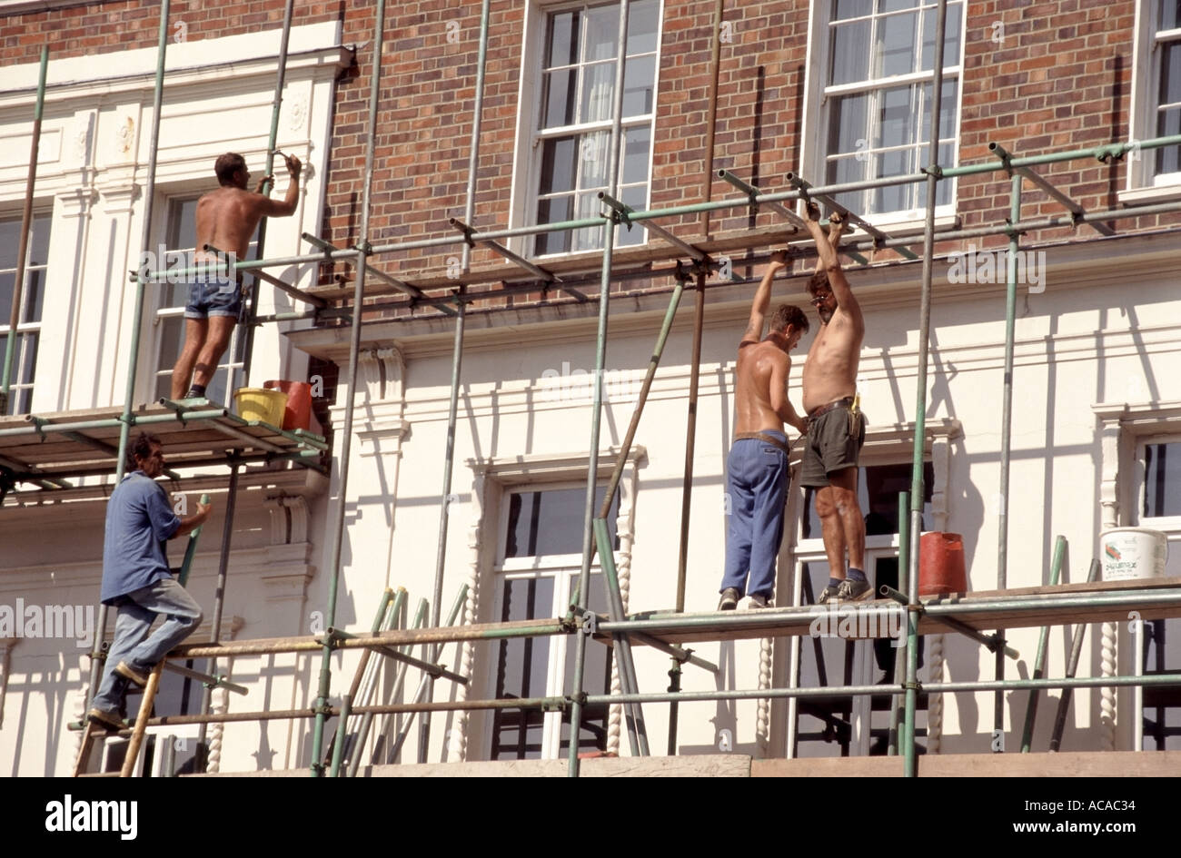 Surrey Guildford scaffolders travaillant sur un échafaudage tubulaire en acier érigée sur la face du bâtiment pour les travaux d'entretien pour procéder Banque D'Images