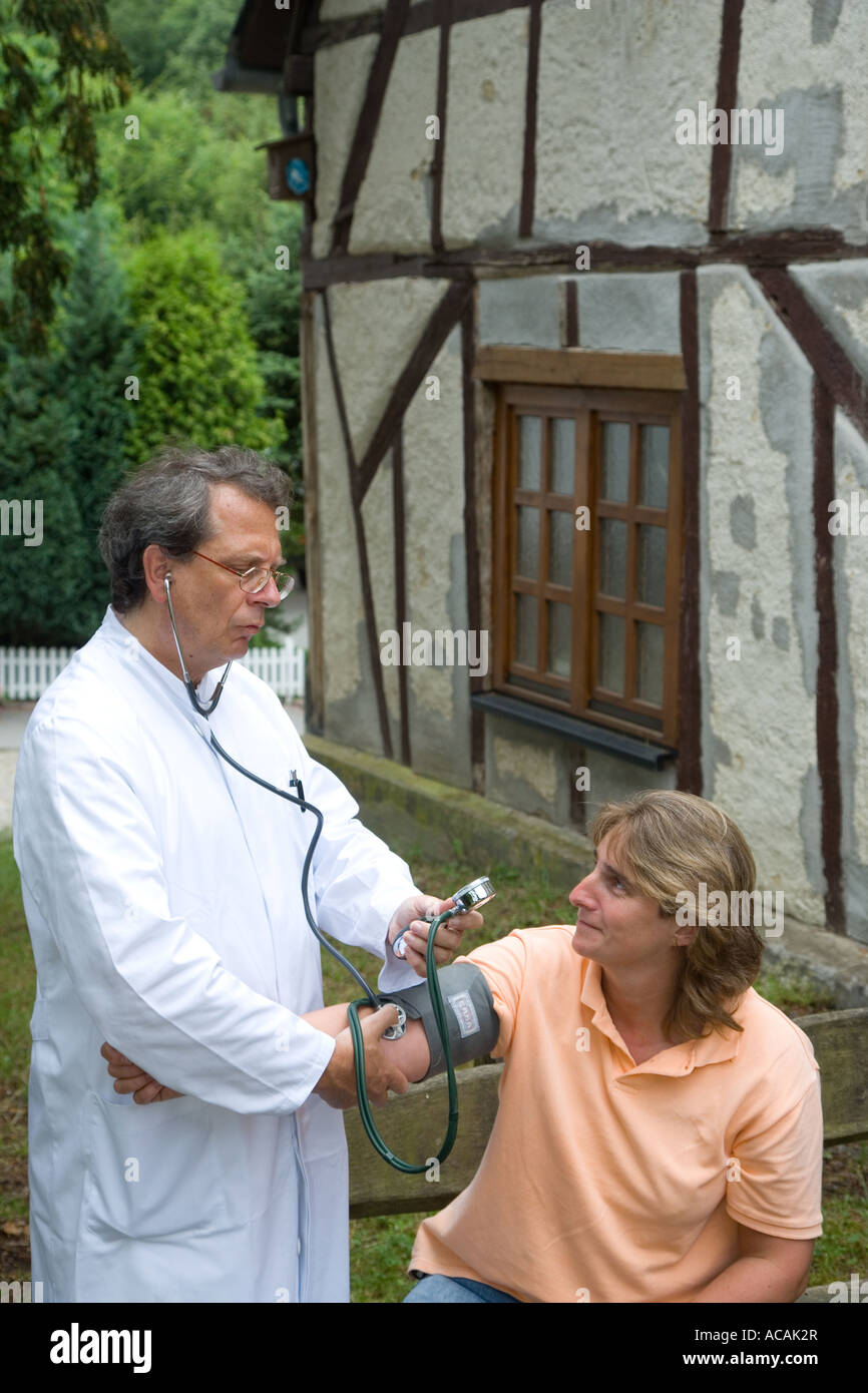 Médecin de campagne au cours d'une visite à domicile avec mesures de la pression artérielle sphygmomanomètre Banque D'Images