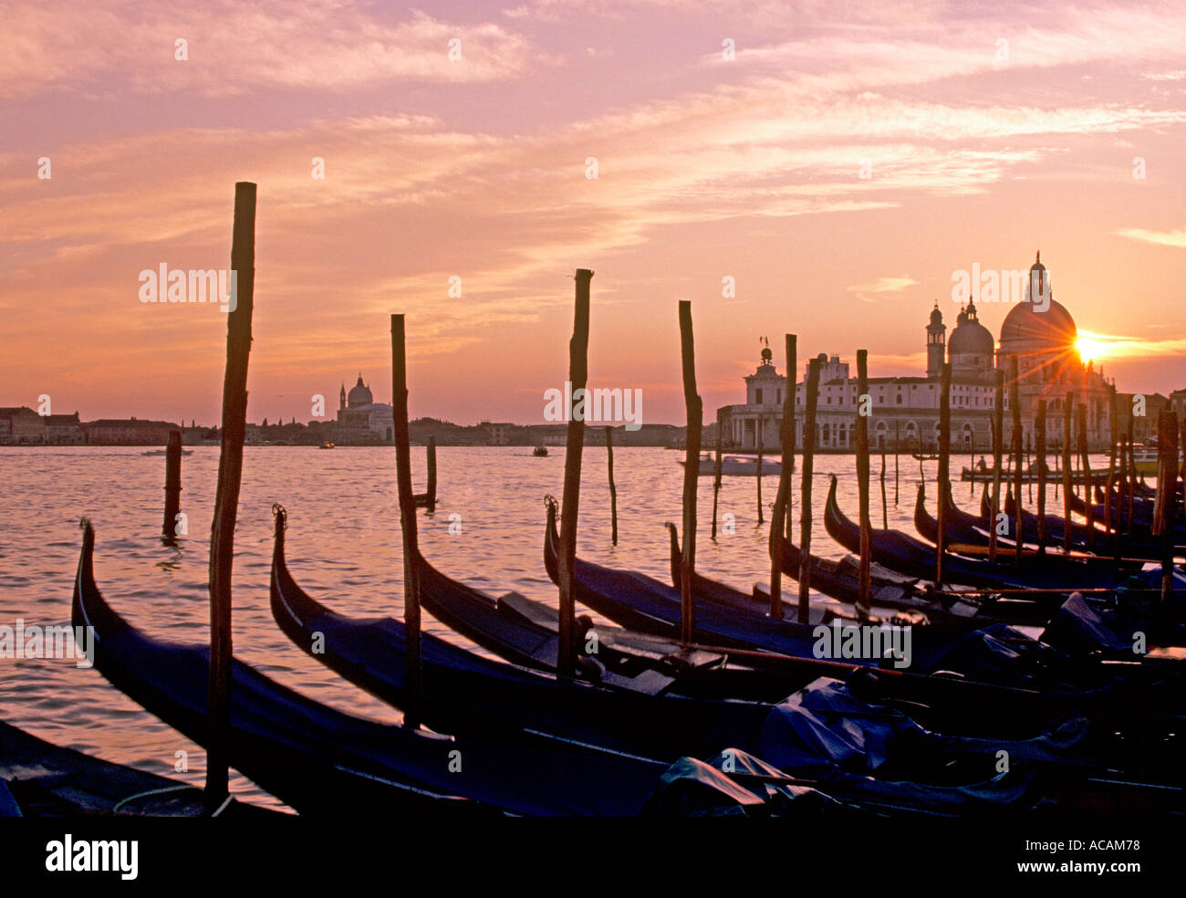 Voir la célèbre de gondoles au coucher du soleil à Lido di San Marco avec la Basilique Santa Maria della Salute, Venise Italie Banque D'Images