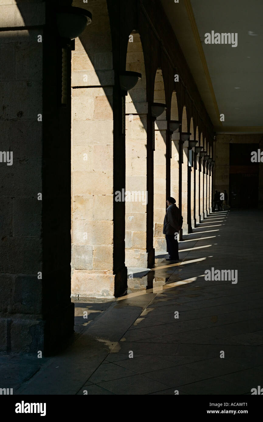 Homme debout sous arcades de la Plaza Nueva, Casco Viejo, Bilbao Banque D'Images